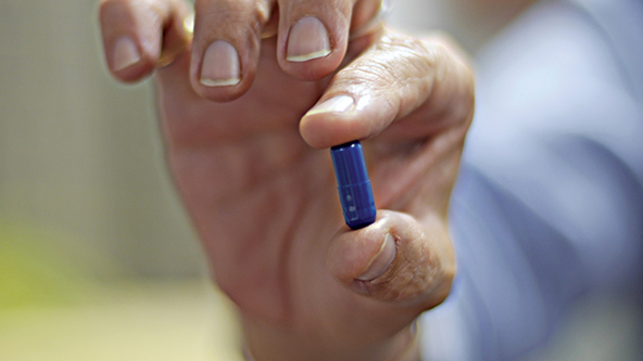 Un terapeuta sostiene una pastilla de MDMA. 