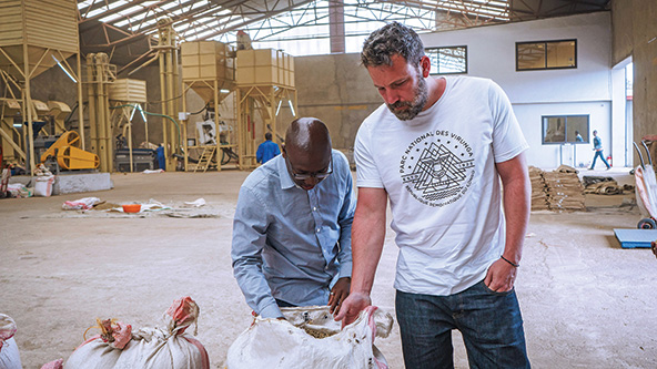 El cofundador de Eastern Congo Initiative (ECI), Ben Affleck (derecha), y el ex miembro del personal de ECI y director de país, Baraka Kasali, inspeccionan los granos en un centro de procesamiento de café. 