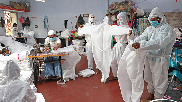 El 5 de abril de 2020, los trabajadores cerca de Kolkata, India, preparan equipos de protección personal para distribuirlos al personal médico durante el cierre nacional del país.