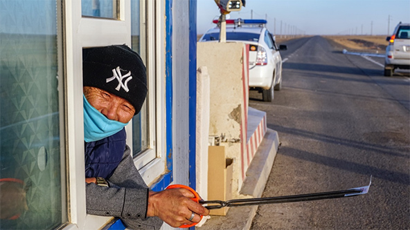 Munkhbaatar Sukhee, cobrador en el puesto de control de Dalanzadgad-Bayandalai en la provincia de Umnugovi en Mongolia, registra vehículos y le da a cada conductor información sobre la prevención del coronavirus (Fotografía de Uranchimeg Tsoghuu)